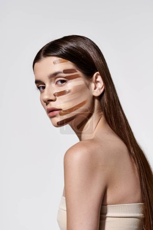 Trendy junge Frau mit Schichten von Fundament verziert, präsentiert komplizierte Make-up-Artistik.