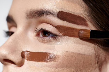 Téléchargez les photos : Beautiful woman showcases her beauty with makeup on her face, including foundation. - en image libre de droit