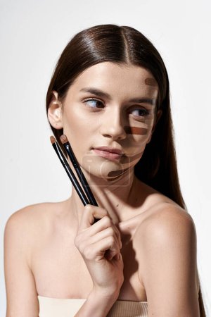 A woman with makeup on her face, holding a brush for cosmetic application.