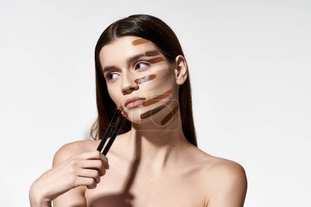 Tasteful woman with various makeup brushes on her face, creating a creative and artistic look with foundation.