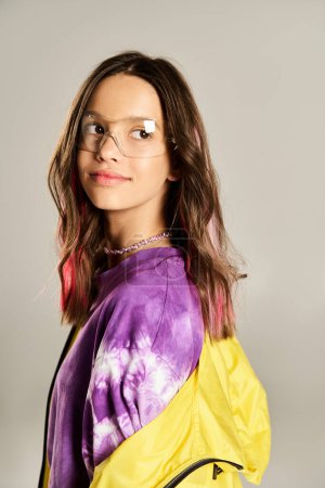 A stylish teenage girl poses confidently in a yellow and purple jacket, showcasing her unique fashion sense and bold personality.