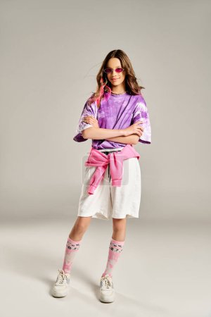 Téléchargez les photos : Une adolescente élégante en chemise violette et jupe blanche pose gracieusement. - en image libre de droit