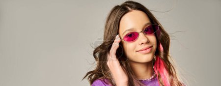 Téléchargez les photos : Une adolescente élégante avec de longs cheveux frappant une pose dans des lunettes de soleil roses. - en image libre de droit