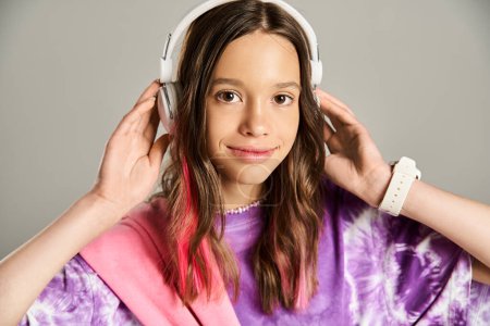 A stylish teenage girl in a vibrant purple shirt enthusiastically listens to music through headphones.