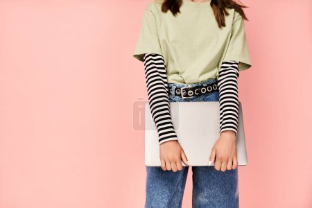 Photo for A stylish teenage girl poses confidently in a green shirt and jeans. - Royalty Free Image