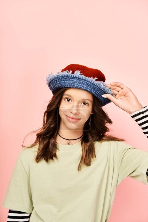 A stylish teenage girl in a striped shirt and hat poses confidently in vibrant attire.