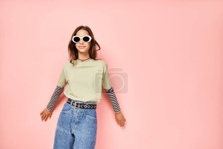 Una adolescente con estilo posa con confianza en una camisa verde vibrante y gafas de sol de moda.