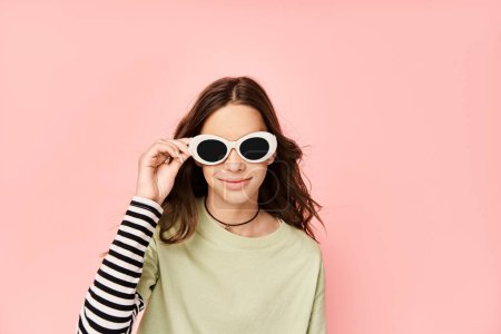 Téléchargez les photos : Une adolescente à la mode pose énergiquement dans une chemise verte et des lunettes de soleil élégantes, respirant la confiance et le style. - en image libre de droit