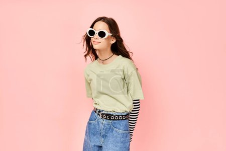 A stylish teenage girl confidently poses in a green shirt and sunglasses, exuding a vibrant and energetic aura.