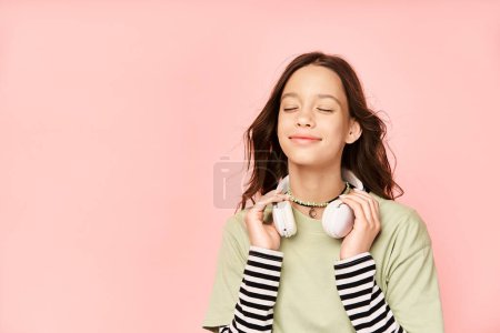Foto de Una elegante adolescente vestida con vibrante atuendo sostiene con gracia dos orbes blancos en sus manos. - Imagen libre de derechos