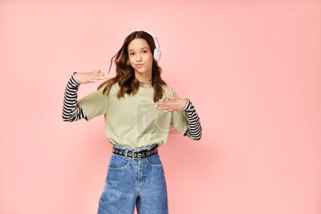Téléchargez les photos : A good looking teenage girl poses actively in stylish vibrant attire of a green shirt and blue jeans. - en image libre de droit