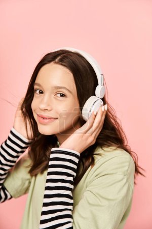 A stylish teenage girl smiles brightly while wearing headphones, exuding happiness and energy.