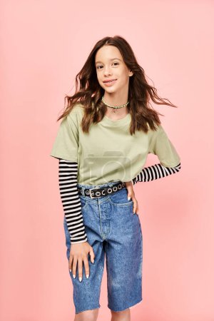 Téléchargez les photos : Une adolescente élégante et belle pose activement dans une chemise verte et un short bleu. - en image libre de droit