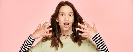 Photo for A teenage girl in vibrant attire with hands up in front of her face, striking a dynamic pose. - Royalty Free Image