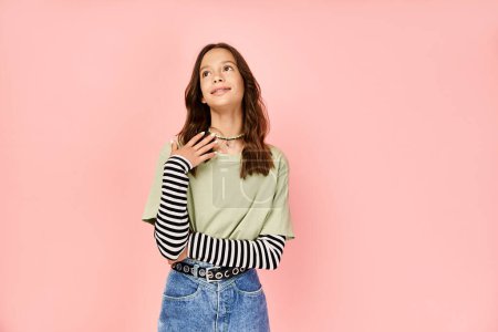 Téléchargez les photos : Stylish teenage girl poses energetically in a green shirt and blue jean skirt. - en image libre de droit