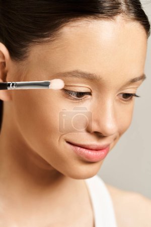 Photo for A teenage girl in vibrant attire actively paints her face with a brush. - Royalty Free Image