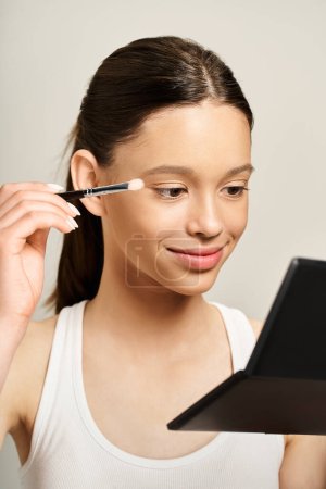 A stylish teenage girl energetically using a brush to apply makeup on her own face, showcasing a fun and artistic form of self-expression.