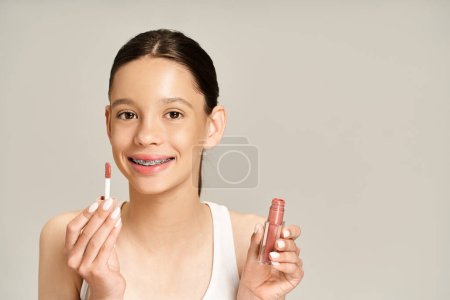 A stylish teenage girl in vibrant attire holding two lipsticks in her hands, exuding confidence and beauty.