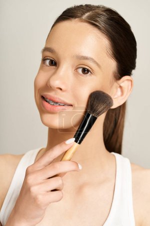 A stylish young woman with vibrant attire delicately holds a makeup brush in her hand, displaying her artistic flair.