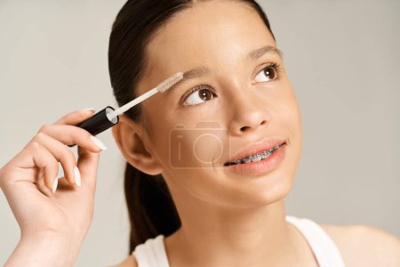 Photo for A stylish teenage girl energetically taking care of her eyebrows. - Royalty Free Image