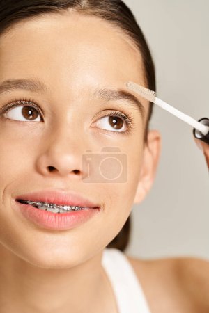 Photo for Pretty teenage girl energetically taking care of her eyebrows. - Royalty Free Image