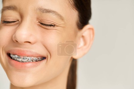 A stylish teenage girl with braces on her teeth smiles brightly, exuding confidence and charm.