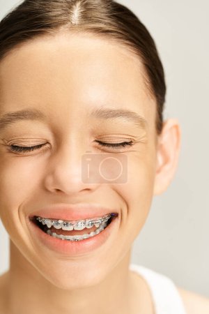 Téléchargez les photos : Une adolescente élégante souriant en toute confiance avec des bretelles sur les dents, mettant en valeur son voyage vers un beau sourire sain. - en image libre de droit