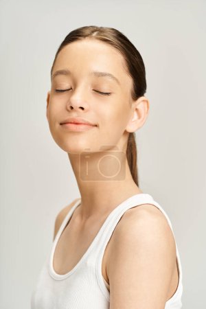 Foto de Una elegante adolescente con los ojos cerrados, encarnando la esencia de la energía vibrante en una pose colorida. - Imagen libre de derechos