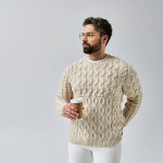 A bearded man exudes charm in a white sweater against a grey background, showcasing a sophisticated and polished look.
