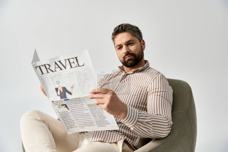 Un hombre elegante con barba sentado en una silla absorto en la lectura de un periódico, exudando sofisticación y encanto.