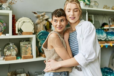 Un couple lesbien amoureux, deux femmes, debout dans un studio d'art avec une connexion tendre.