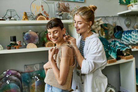 Photo for Two women, one assisting the other in putting on a necklace with care and creativity. - Royalty Free Image