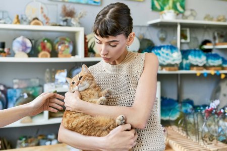 A woman tenderly holds a cat in her arms.
