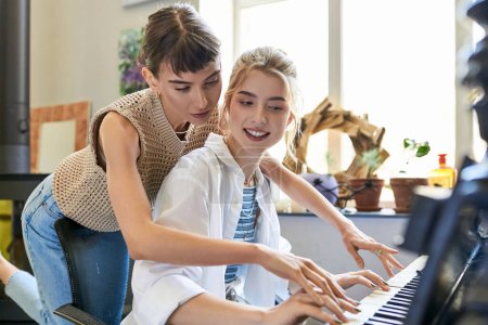 Lesbisches Paar spielt leidenschaftlich Klavier im Kunststudio.