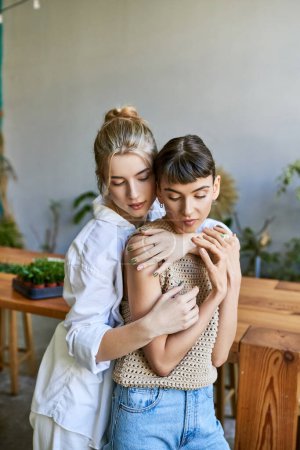 Two women hugging tenderly in an artsy studio setting.