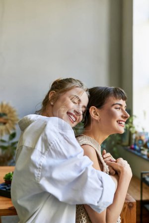 Photo for A loving lesbian couple standing together in an art studio. - Royalty Free Image