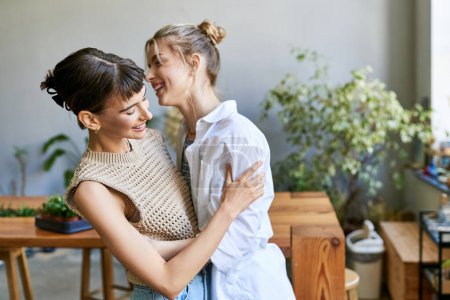 Téléchargez les photos : Deux femmes, un couple lesbien amoureux, debout ensemble dans un studio d'art. - en image libre de droit