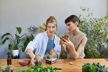Two women absorbed in gardening at a table in an art studio.