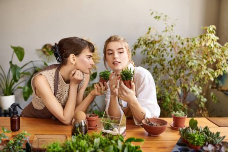 Kunstvoll sitzen zwei Frauen an einem Tisch, umgeben von üppig grünen Pflanzen..