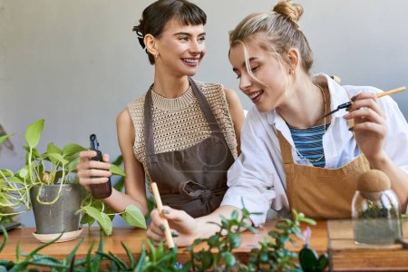 Two women in aprons nurture plants in an art studio.