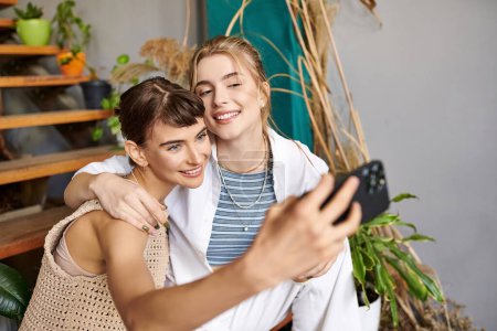 Eine Frau macht ein Selfie mit ihrem Freund in einem Kunstatelier.