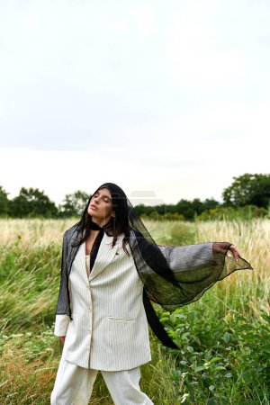 Una hermosa joven vestida de blanco se levanta con gracia en un campo de hierba alta, disfrutando de la brisa del verano.
