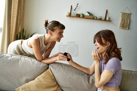 Dos mujeres en traje cómodo charlando en un sofá.