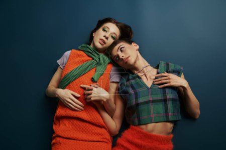 Two women in cozy outfits embrace, radiating grace and harmony.