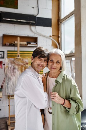 Foto de A mature lesbian couple standing side by side in an art studio. - Imagen libre de derechos