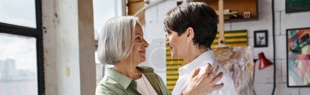 Photo for A mature lesbian couple standing confidently side by side in an art studio. - Royalty Free Image