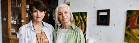 Téléchargez les photos : Mature lesbienne couple dans art studio, debout côte à côte. - en image libre de droit