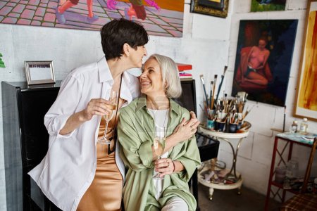Two woman sit together in an art studio.