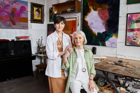 Photo for Two women stand together in an art studio. - Royalty Free Image