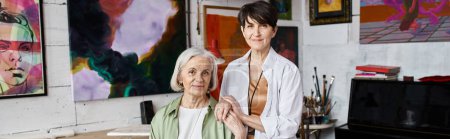 Foto de Two woman standing in front of paintings in an art studio. - Imagen libre de derechos